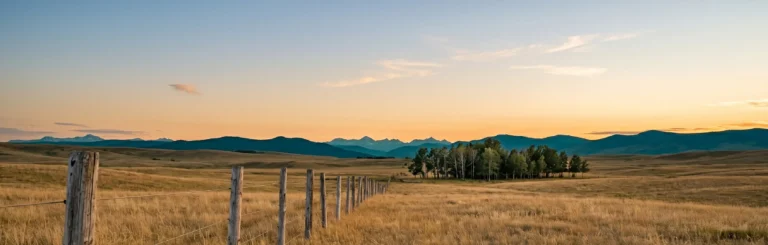 Alberta rural fence line at golden hour with the Rocky Mountain foothills — animal cruelty lawyer in Alberta